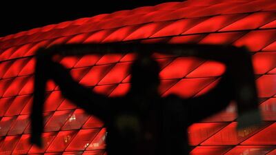 A fan poses outside the Allianz Arena on Wednesday night prior to the Champions League match between Arsenal and hosts Bayern Munich. Lennart Preiss / Bongarts / Getty Images
