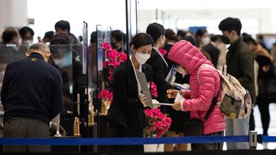 A member of event staff wearing a protective mask registers an attendee arriving for the Samsung Electronics Co. annual general meeting at the Suwon Convention Center in Suwon, South Korea. Bloomberg