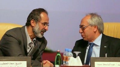 Ahmed Moaz Al Khatib, left, a moderate who quit Syria three months ago, chats with outgoing National Syrian Council chief Abdulbaset Saida during the meeting to form Syria’s new opposition.