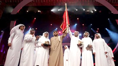 Rashid Ahmed Al Rumaithi, in brown, won the fifth edition of Million's Poet in 2012. Courtesy Million's Poet
