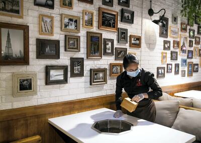 A waitress sanitises the hotpot station after customers have left at Nine Squares Hotpot in Dubai International City. Reem Mohammed / The National