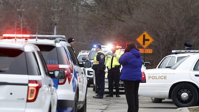 A woman stands by police officers on call at the site of a bus accident. Mykal McEldowney / The Indianapolis Star via AP