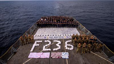 HMS Montrose ship’s company assemble on the flight deck with a large quantity of narcotics seized from a dhow in the Arabian Gulf. (Photo: LS(EW) Parsons RN)