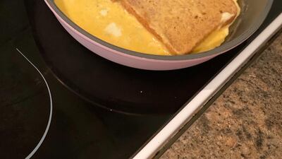 Dip the bread in the still-liquid egg and then flip it, using your spatula or very carefully with your fingers - don't burn yourself! You want to make sure the top of the bread is coated with egg. Farah Andrews / The National