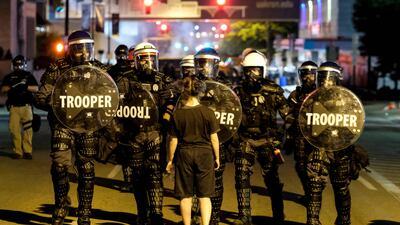 A demonstrator confronts troopers in riot gear in Akron, Ohio, after anger on the streets following the police shooting of an unarmed black man. AFP