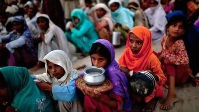 Displaced villagers queue for soup and rations in the Sultan Colony Army flood relief camp in Punjab.