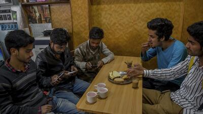 Kashmiri students browse on their smartphones in a cafe in Srinagar. Dar Yasin / AP Photo