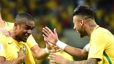 Brazil’s Douglas Costa (L) celebrates with teammate Neymar after scoring against Uruguay during their Russia 2018 FIFA World Cup South American Qualifiers’ football match, in Recife, northeastern Brazil, on March 25, 2016. AFP PHOTO / CHRISTOPHE SIMON