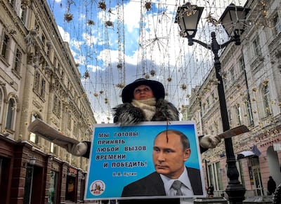 An activist distributes election leaflets in support of Vladimir Putin in March 2018. Yuri Kadobnov / AFP