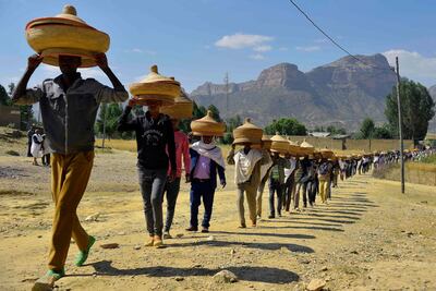 Ethiopian men carrying traditional hand-woven food baskets as they walk to a reconciliation meeting in the Irob district in northern Ethiopia near the border with Eritrea, in the Tigray region, the area most affected by the 1998-2000 border war and the long, bitter stalemate that followed. Michael Tewelde / AFP