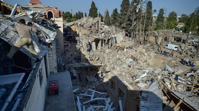 People look at destroyed houses in Ganja, Azerbaijan, a day after shelling by Armenian artillery during fighting over the separatist region of Nagorno-Karabakh. AP