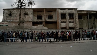 Iraqis wait to cast their vote in the country's parliamentary elections at a polling site in a battle-damaged building in west Mosul, Iraq, on Saturday, May 12, 2018. Maya Alleruzzo / AP Photo