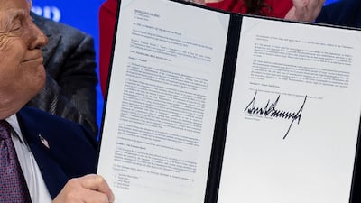 US President Donald Trump holds a signed resolution at the announcement of his Board of Peace initiative. Reuters