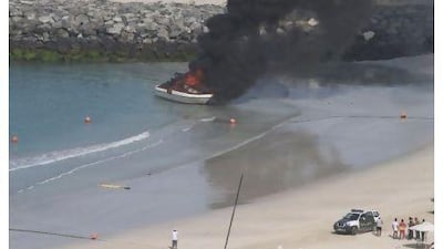 People can only watch as the leisure boat from Nautica 1992 Water Sports is destroyed by fire in Jumeirah yesterday. Courtesy of Mike Westpheling