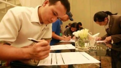 Joel Berina Favia and Maria Aiza Agustin register during an absentee voting registration session at the Sheraton Hotel in Abu Dhabi.