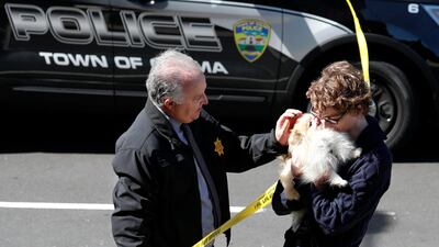 Chief of Burlingame police Eric Wollman reunites a YouTube employee with his dog, Kimba, after he was left at the scene following the shooting. EPA/JOHN G. MABANGLO
