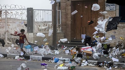 A boy walks as rubbish blows around in the wind amid a sandstorm in Gaza City. AFP