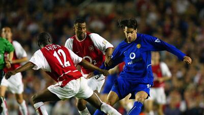 Ruud Van Nistelrooy of Manchester United is tackled by Lauren. Getty