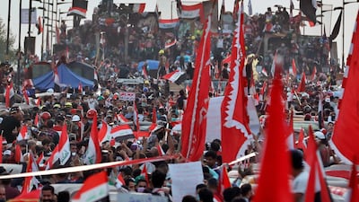 Anti-government protesters stand on barriers set up by Iraqi security to close the Joumhouriya bridge leading to the Green Zone government areas in Baghdad. AP Photo