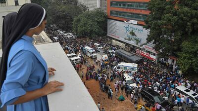 Nuns look on at fans of actor Puneeth Rajkumar waiting outside a hospital after news spread of his critical health condition. AFP