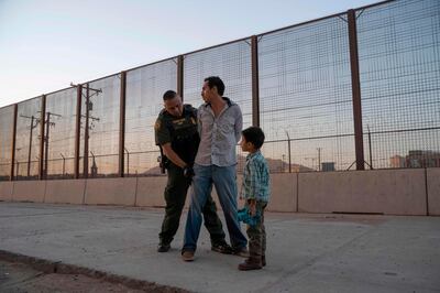 José, 27, with his son José Daniel, 6, is searched by US Customs and Border Protection Agent Frank Pino, May 16, 2019, in El Paso, Texas. AFP