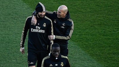 Real Madrid manager Zinedine Zidane, right, talks with forward Karim Benzema. AFP