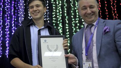 Roy Hayyat who scored the highest mark in the world for Edexcel GCSE in French receives the award from the principal Andrew Thomas at the Al Ain English Speaking School in Al Ain. Satish Kumar / The National