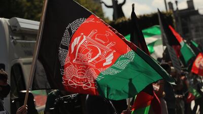 People wave Afghan flags during a protest. Charity workers have accused the British government of doing too little to help at-risk Afghans who have been in hiding since the Taliban's takeover of Kabul. PA