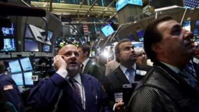 Traders pause to watch the US House of Representatives vote on television on the floor of the New York Stock Exchange.