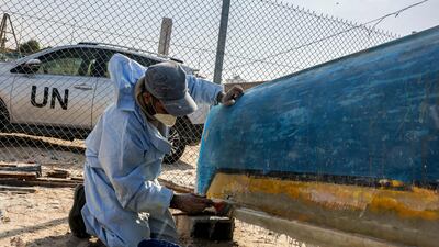 A craftsman uses fibreglass to repair a fishing boat at a workshop in Gaza. All photos: AFP