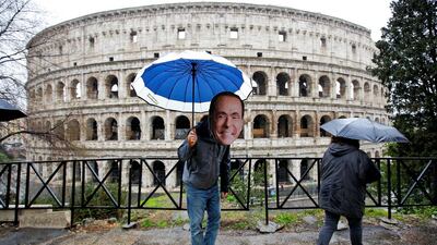 An activist wearing a mask of Forza Italia party leader Silvio Berlusconi poses during a tour, the day after Italy's parliamentary election, in Rome, Italy March 5, 2018. REUTERS/Max Rossi