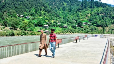 Kashmiris walk at a tourist place alongside a river near the Line of Control, the de facto border between Pakistan and India, in Neelum Valley of Pakistan-administered Kashmir. AFP