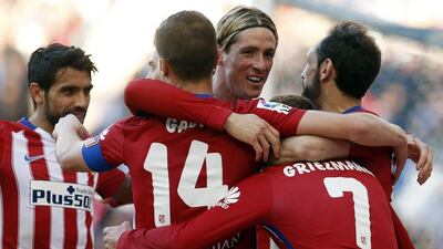 Atletico Madrid's French forward Antoine Griezmann (R) celebrates a goal with Atletico Madrid's forward Fernando Torres (3rd R) and other teammates during the Spanish league football match RCD Espanyol vs Club Atletico de Madrid at the Cornella-El Prat stadium in Cornella de Llobregat on April 9, 2016. / AFP / PAU BARRENA