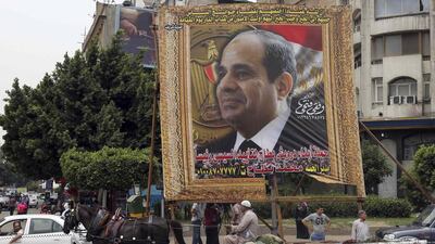 An Egyptian man on horse cart rides past a huge banner for Egypt's former army chief Field Marshal Abdel Fattah El Sisi in Cairo, May 6, 2014. Reuters