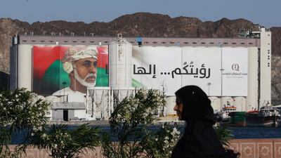 A woman walks past a portrait of Oman's Sultan Qaboos bin Said on a building in Muscat, Oman. Reuters