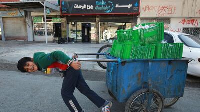 A child pulls a handcart in the Wahdat district of Jordan's capital Amman. Many children have been forced into working due to the economic impact of the Covid-19 pandemic. AFP