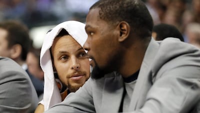 Golden State Warriors guard Stephen Curry, left, talks with Kevin Durant, right, on the bench during their game against the Dallas Mavericks on Tuesday, March 21, 2017, in Dallas. Tony Gutierrez / AP