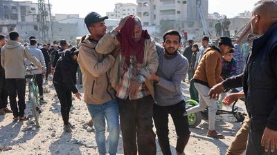 Palestinians help an injured elderly man following an Israeli strike on a metalsmith workshop at the Zaytoun neighbouhood in Gaza City on April 13. AFP