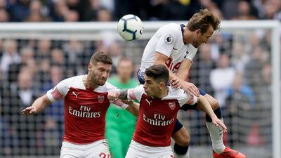 Tottenham's Harry Kane, right, jumps for the ball with Arsenal's Shkodran Mustafi, left, and Torreira. AP Photo