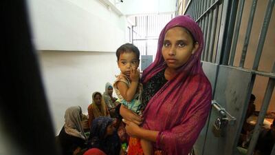 A Rohingya woman and her baby are seen detained in a police station after a fishing boat carrying more than sixty Rohingya refugees was found beached at Rawi island in Thailand. Reuters
