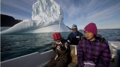 Inuit hunter Nukappi Brandt steers his small boat outside Qeqertarsuaq, Disko Island, alongside his daughters Aaneeraq, 9, right, and Luusi, 8. Mr Brandt, 49, said winter sea ice became too thin to support dogsleds about 20 years ago and seal hunting ceased to be a sustainable way of life.
