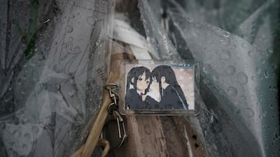 A keychain with a cartoon image is placed on top of flowers. AP Photo