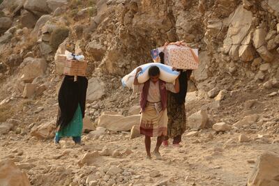 Yemenis carry relief supplies after Houthi rebels besieged the city of Taiz. AP