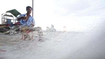 Tensions with China in disputed waters had been costly to Vietnam's fishermen. Above, Vietnamese fisherman Nguyen Van Dung tends to a fishing net on Ly Son island. Kham / Reuters