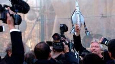 Sir Richard Branson, founder of Virgin Galactic, holds a model of his spaceship at a news conference in New York last year. The planes are currently in testing.
