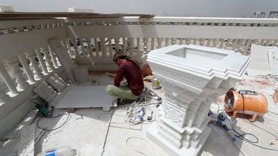 A worker adds some final touches to the temple exterior. Work began in 2020.