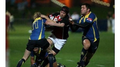 ABU DHABI, UNITED ARAB EMIRATES - April 29,2011: Players of Kazakhstan trying to stop Scott Kerr (center in helmet) of UAE team during the rugby match between UAE vs Kazakhstan at Zayed Sports City Rugby fields in Abu Dhabi. (Pawan Singh / The National) For Sports. Story by Paul