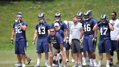 Jeff Fisher, centre, St Louis Rams head coach, does not think he needs to watch his veterans day and night during camp. He will let players with four-plus years in the NFL commute to pre-season training.