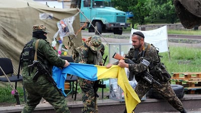 Pro-Russian fighters of the Vostok (East) battalion rip apart a Ukrainian flag in the eastern city of Donetsk in May 29. The new president Petro Poroshenko faces a divided country in turmoil. Viktor Drachev / AFP