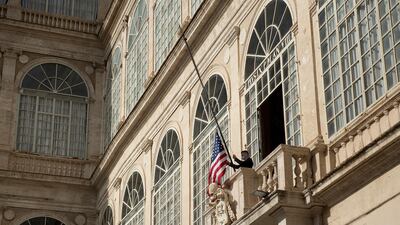 A member of the Swiss Guard raises the US flag above the San Damaso Courtyard. AFP